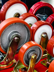 Different types of caster wheels arranged for display in a workshop setting