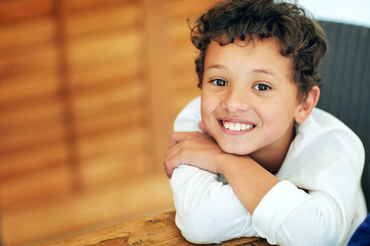 Portrait, smile and space with boy child at table in home for development, future or growth. Break, relax and youth with cute or happy kid in apartment for confident, early childhood and satisfaction