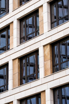 Modern office architecture facade building with stone windows in an urban setting showing refined texture and pattern for corporate real estate background