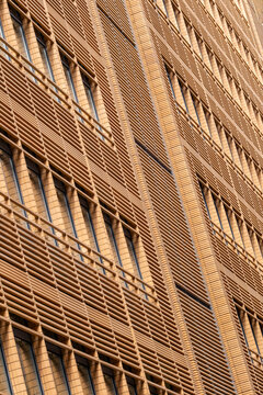 Gold modern architecture facade building with metal mesh lines forming warm texture and pattern on contemporary urban exterior screening detail