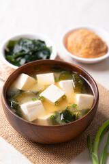 Healthy Japanese miso soup with soft tofu and seaweed in a wooden bowl