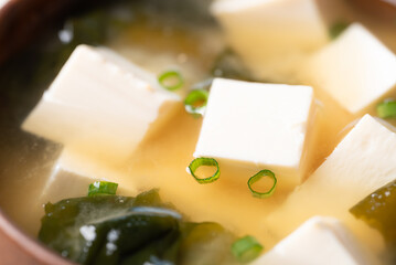 Close up of healthy miso soup with soft tofu, seaweed and spring onion in a bowl