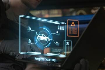 Mechanic using laptop to engine scanning process with diagnostics of a car.