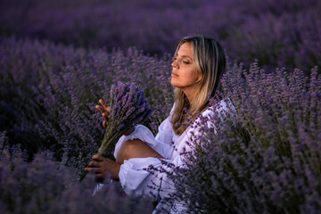 Lavender Field Woman Sunset Provence: Serene woman sits amidst blooming lavender, holding flowers...