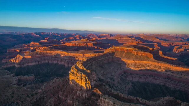 Approaching drone camera revealing central butte and curving canyon rim, highlighting golden strata