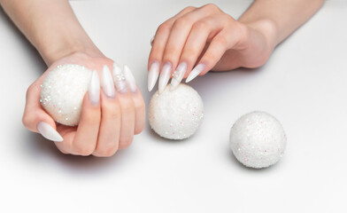 Woman hands holding sparkling christmas ornaments with long nails © Olena Rudo