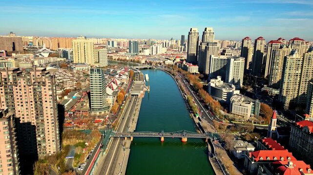 Aerial view of the Haihe River winding through the urban landscape, contrasting with the towering skyscrapers, Tianjin, Tianjin, China.