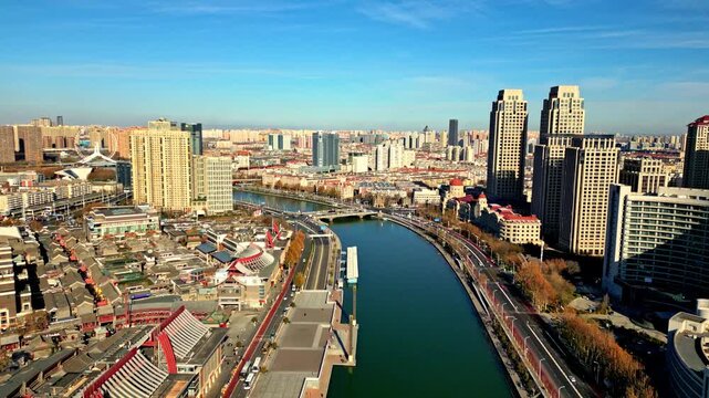 Aerial view of the winding Hai River cutting through the city, framed by skyscrapers and the Tianjin Eye, showcasing urban development, Tianjin, Tianjin, China.