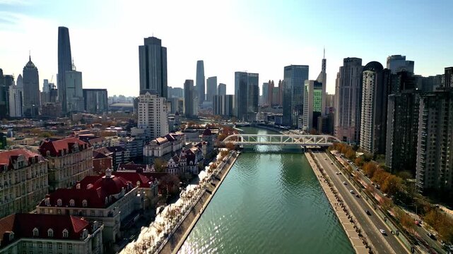 Aerial view of the Hai River flowing through the city with bridges and buildings showcasing a mix of modern and traditional architecture, Tianjin, Tianjin, China.