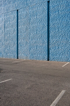 Blue wall texture with minimal urban parking asphalt and empty space background for branding mockups outdoor advertising and copyspace