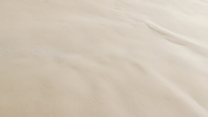 Obraz premium Smooth beige sand texture surface with subtle light and shadow for natural backdrop needs