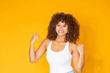 isolated young woman with afro hair, expressing success and triumph