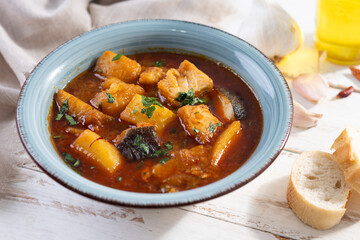 Cod with potatoes on white wooden table.Traditional Spanish dish
