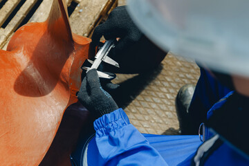 Engineer measuring ship components in industrial shipyard environment