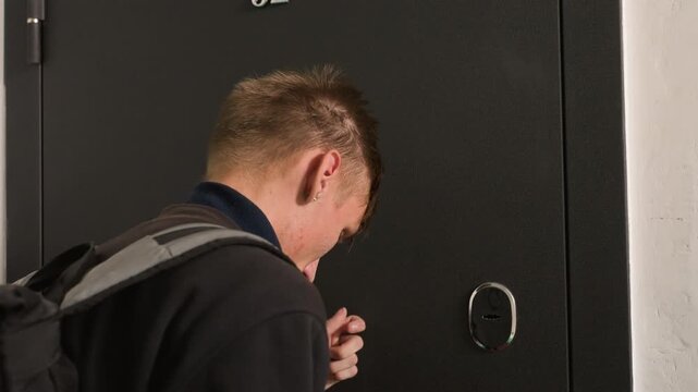 Young caucasian man at door backpacked student knocks at metal apartment entrance peers through peephole resident caucasian woman opens slightly and smiles friendly exchange hints at delivery