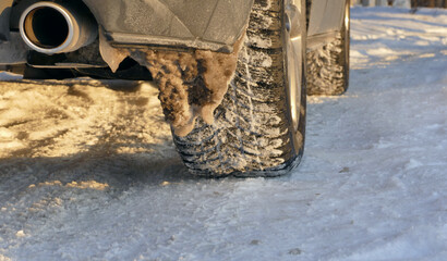 Winter tires on a car wheels on a completely snow covered country road  