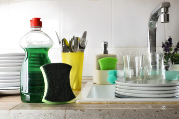 Hand dishwashing product on bench with sink full of plates