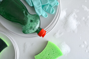 Hand washing dishes background with dishes and product top view