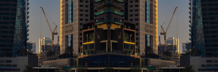 Evening view of the city. Orange sunlight, skyscrapers, buildings, and city streets. On the streets of the Emirates, in a public space.
