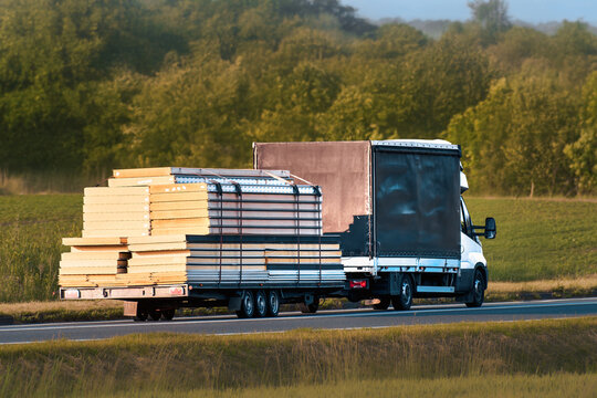 Black truck driving with construction materials