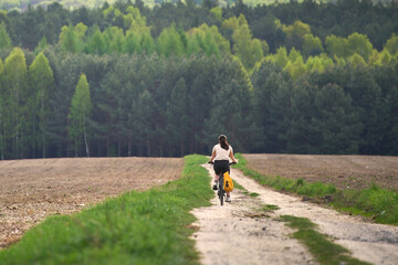 Obraz premium Back view of cyclist on country path