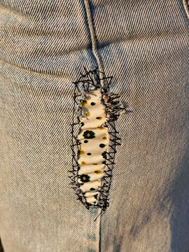 A patched-up pair of jeans with colorful fabric