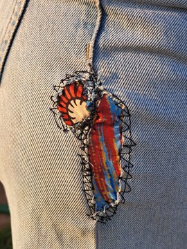 A patched-up pair of jeans with colorful fabric