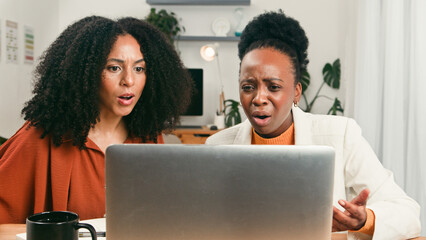 Diverse Startup Team Shocked and Focused While Reviewing Results On Laptop In Modern Office
