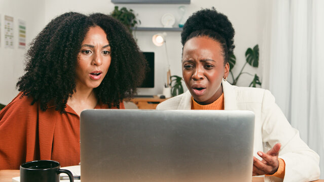 Diverse Startup Team Shocked and Focused While Reviewing Results On Laptop In Modern Office - Powered by Adobe