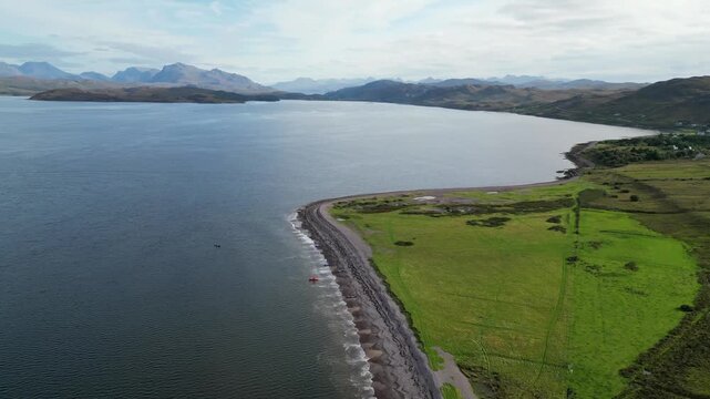 Aerial view of canoes arriving at a beach on Loch Ewe with Poolewe visible in the distance.
