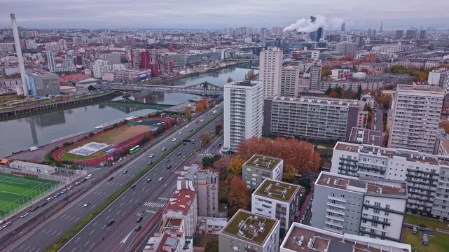 Aerial dolly to Seine and Marne rivers with railway bridge peripherique and Eiffel Tower distant, smoke rises off top of apartment buildings