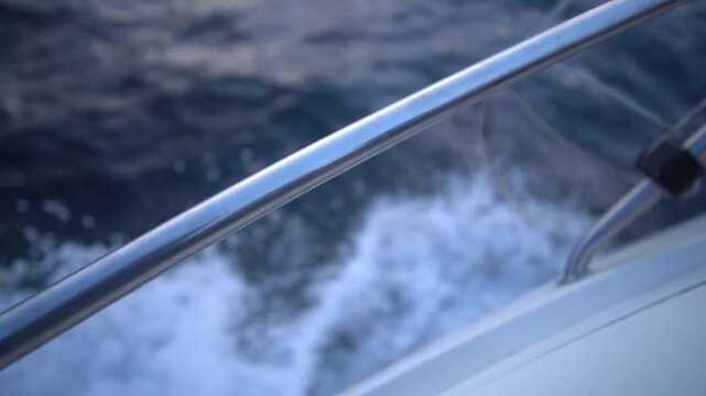 Boat Water Speed stainless steel railing close up while traveling fast across dark blue ocean waves