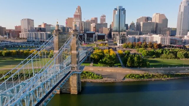 Aerial view of the Roebling Bridge stretching towards the city skyline with its towering buildings and vibrant greenery, Cincinnati, Ohio, United States.
