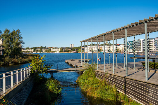 Modern bridge pier on waterfront canal beside promenade architecture in urban Stockholm Sweden with clean lines and bright summer daylight