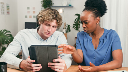 Young Team Collaborating Over Tablet in a Modern Startup Office Setting