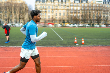 Fototapeta premium Black man running on track in paris city