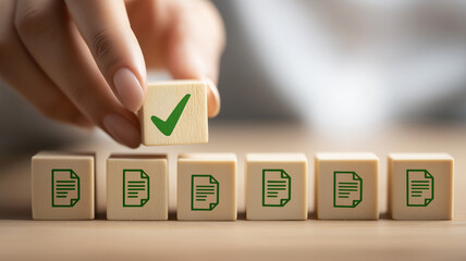 Hand putting wooden cube with green check mark symbol on document files symbolizing approval process