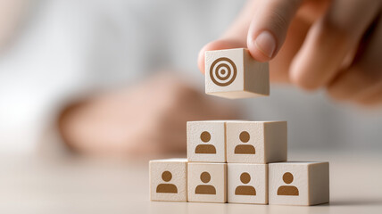 Hand putting wooden cube block on top pyramid with goal icon for business strategy and talent management concept