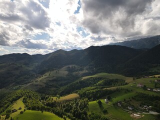 Dramatic Cloudy Sky Over Green Mountain Landscape with Rural Houses