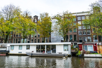 Amsterdam Canal with Houseboat traditional floating house Building. Boat home on water in Netherlands. Outdoor