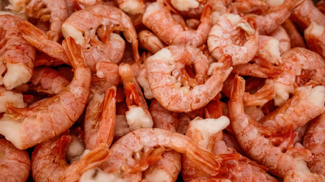 Frozen unpeeled shrimps seafood background. Heap of frozen raw unpeeled shrimps with shells, seafood texture background for market display, packaging design or restaurant menu.