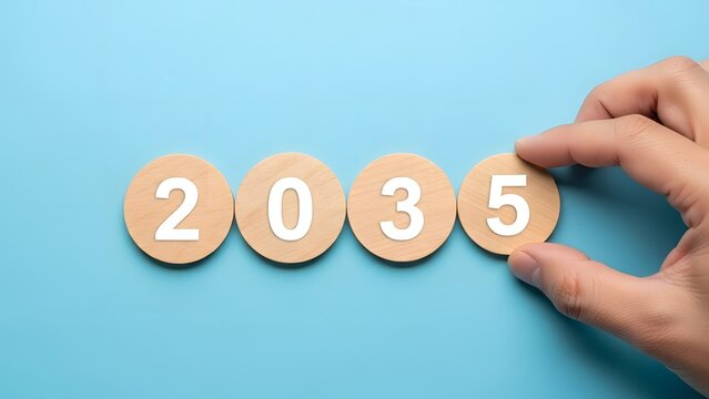 Hand arranging wooden discs with numbers forming the year 2035