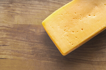 piece of cheese close-up on a wooden kitchen board