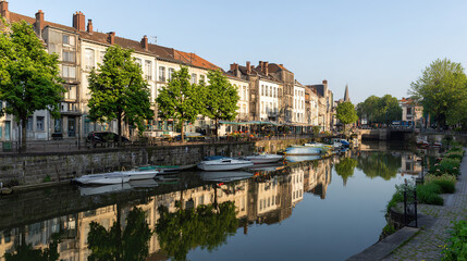 Obraz premium gondolas. Historic canal lined with stone buildings and gondolas, reflecting in the calm morning water. real-estate listings. 
