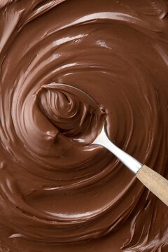 Chocolate hazelnut spread stirred with a spoon. Full frame. Top view