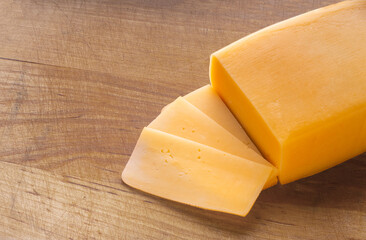 piece of cheese close-up on a wooden kitchen board