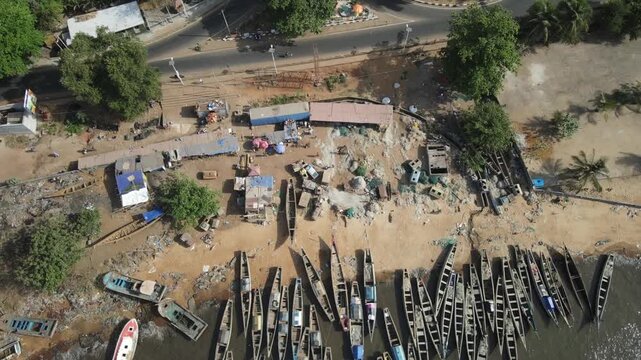 Aerial view of a roundabout with lush green trees surrounded by a coastal road near the beach, Freetown, Sierra Leone.