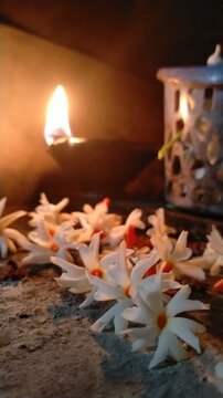 Traditional Oil Lamp with Night Jasmine Flowers Burning in Dark Spiritual Background	