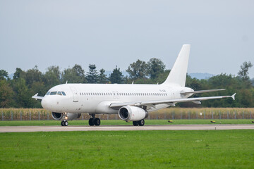 Airbus A320 on runway preparing for takeoff at regional airport in daytime