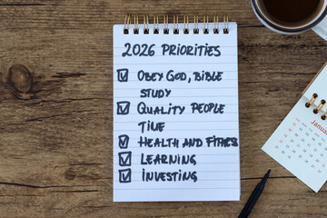 Obraz premium 2026 priorities to obey God, bible study, time management, health, learning, investment text in notebook with coffee cup and calendar. Christian to do list, goals, and aspirations concept.